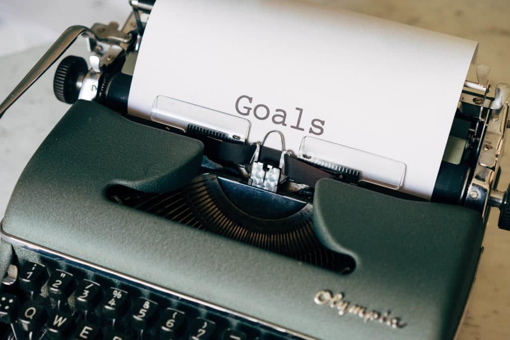A typewriter with a piece of paper in it that has the word "Goals on it"