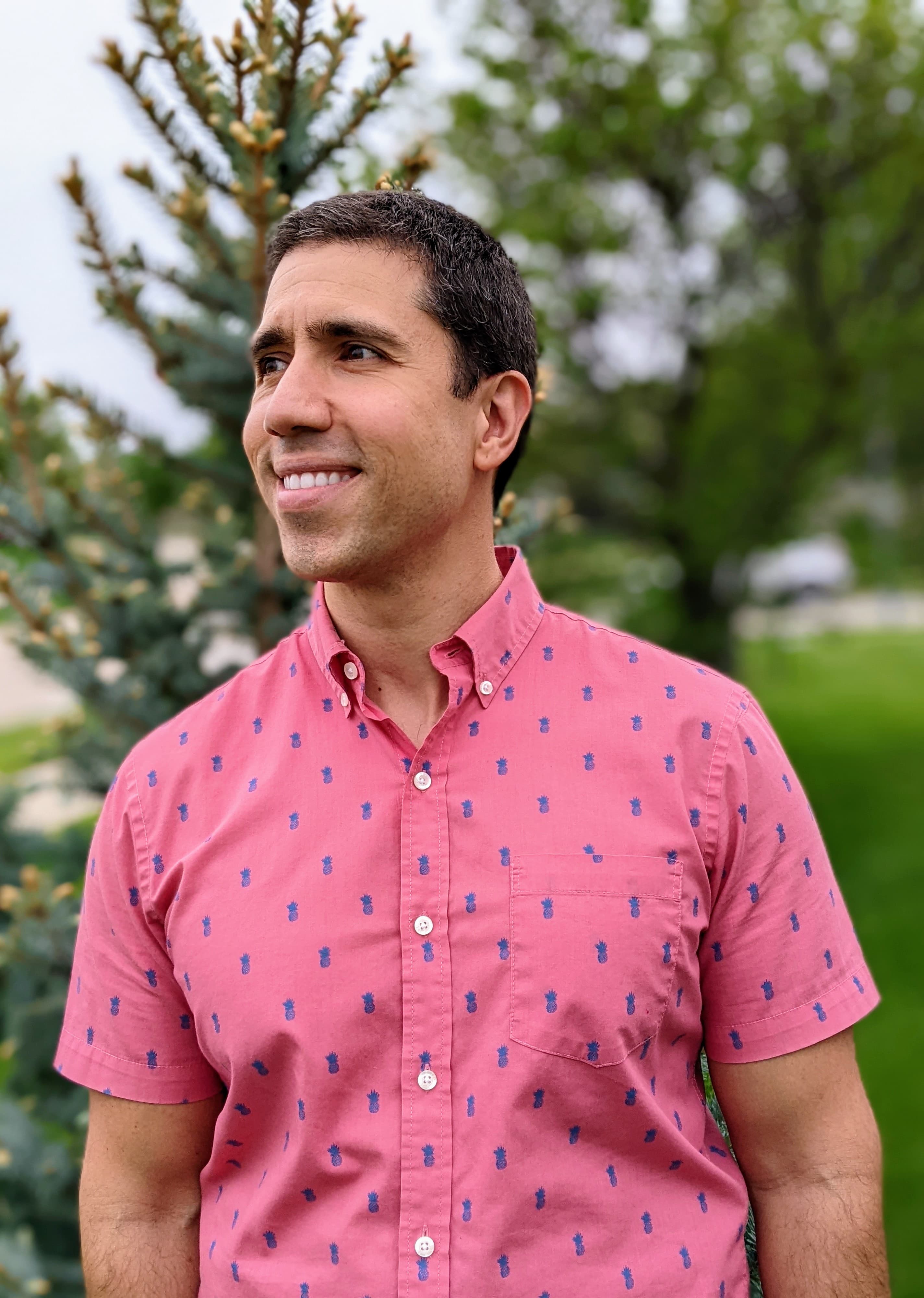 A photograph of Victor Santos, a smiling man with dark hair and a pink collared shirt.