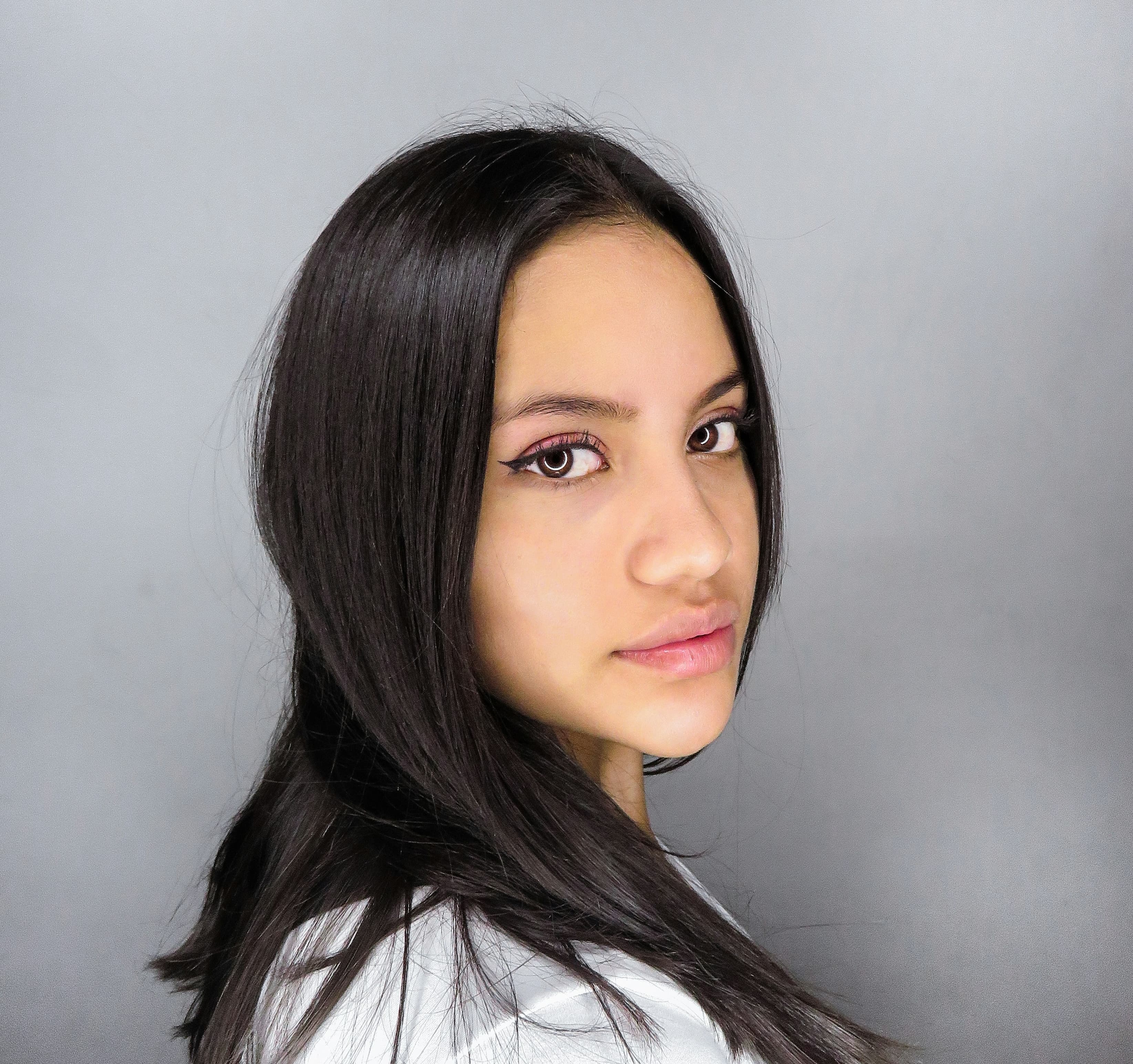 A photo of a young woman with brown skin and very straight dark hair.