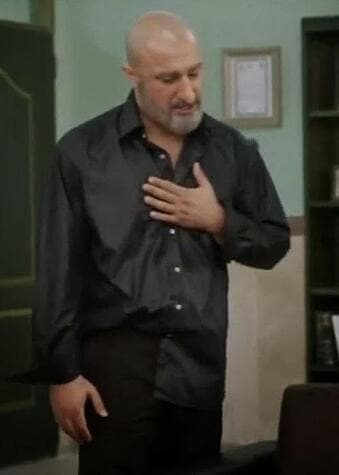 Man placing his hand over his chest while bowing his head slightly to express sincerity