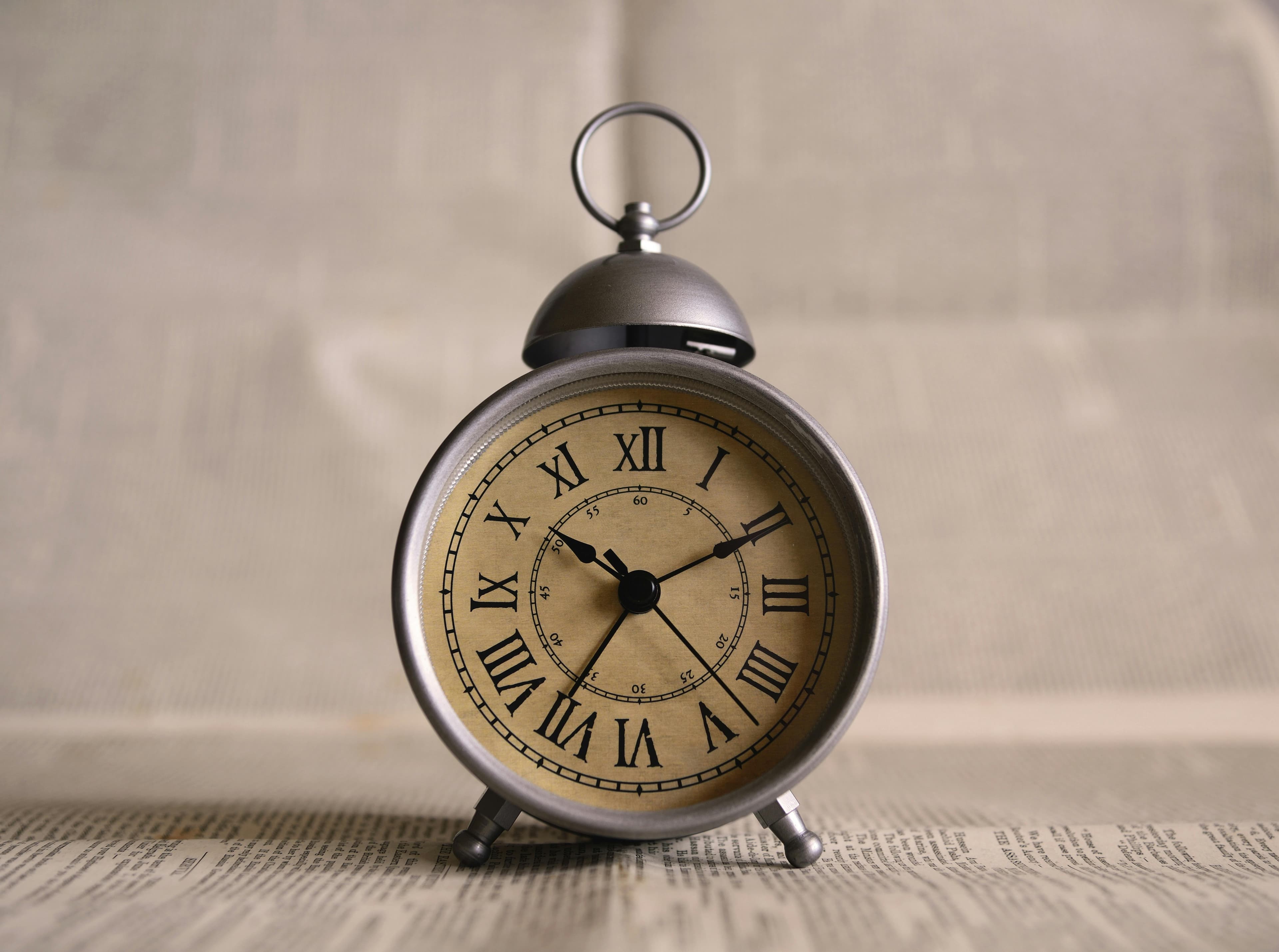 The face of an old-fashioned alarm clock with roman numerals.