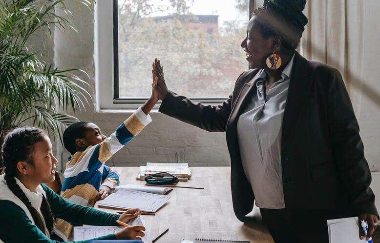 A teacher high-fiving one of her students