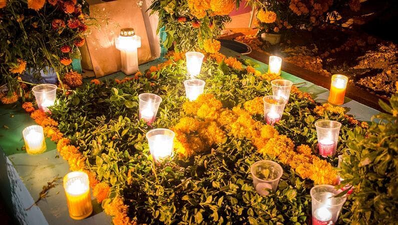 A gravesite decorated with flowers and candles
