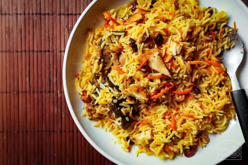 A plate of Afghan yellow rice with lamb, carrots, and raisins