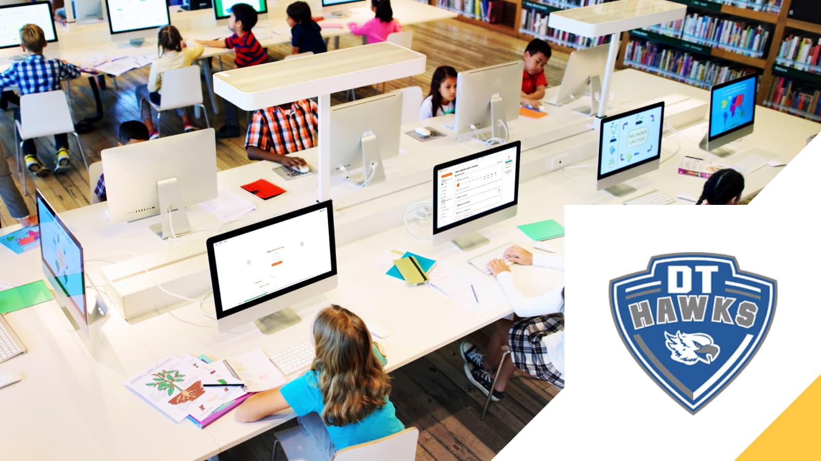 Dennis Township students at work in a school computer lab, beside the district's Hawks emblem