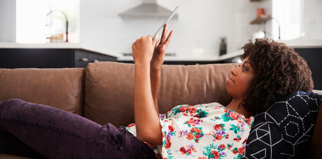 A reader using Mango on a tablet at home on the sofa