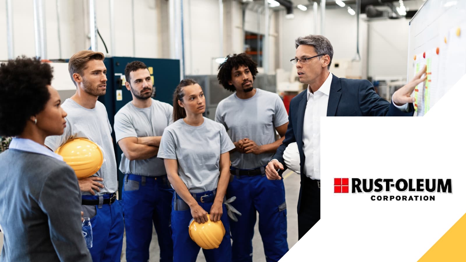 A Rust-Oleum team gathered around a colleague presenting, beside the company's logo