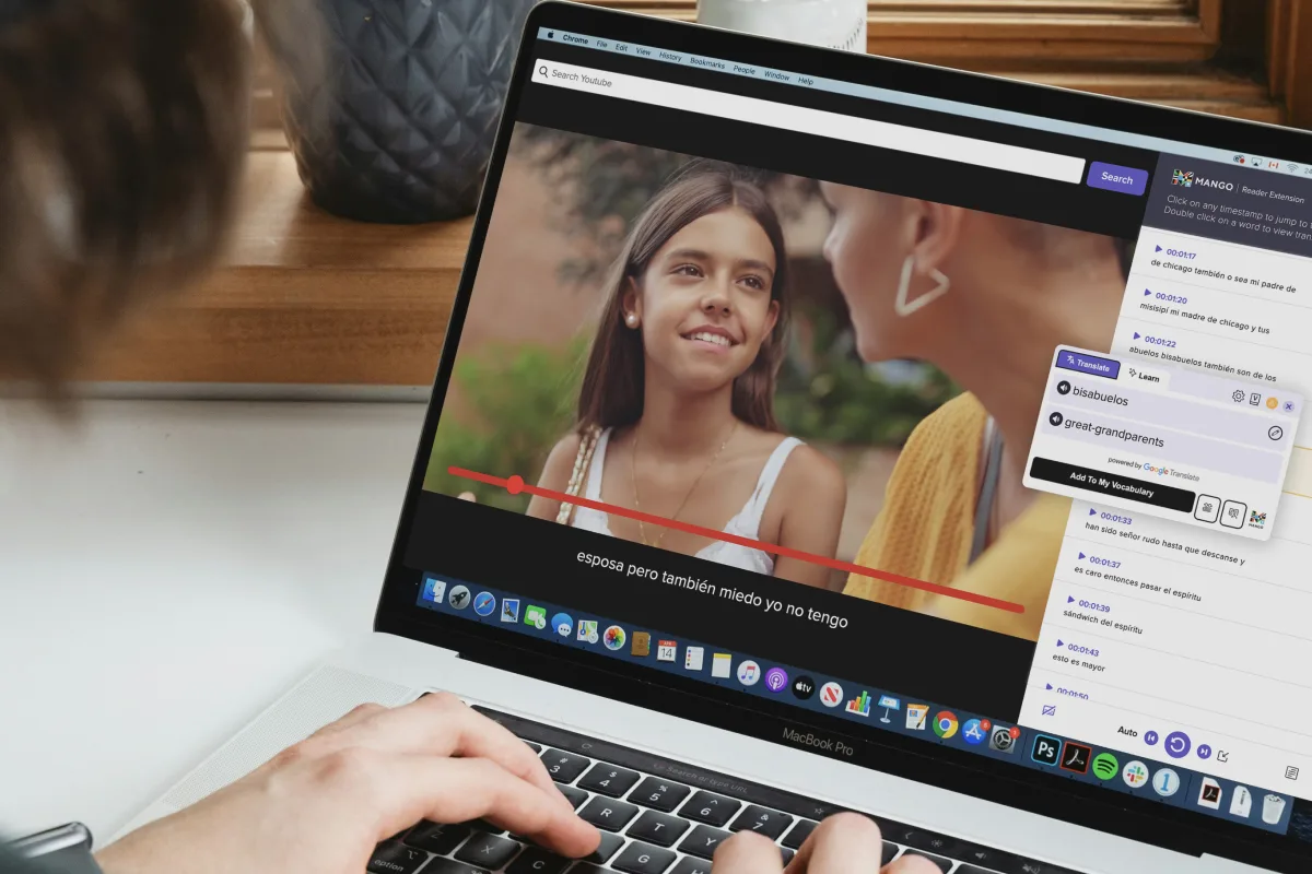 A laptop playing a Spanish-language video beside Mango Reader’s subtitle panel, with the popup translating “bisabuelos” as “great-grandparents”.