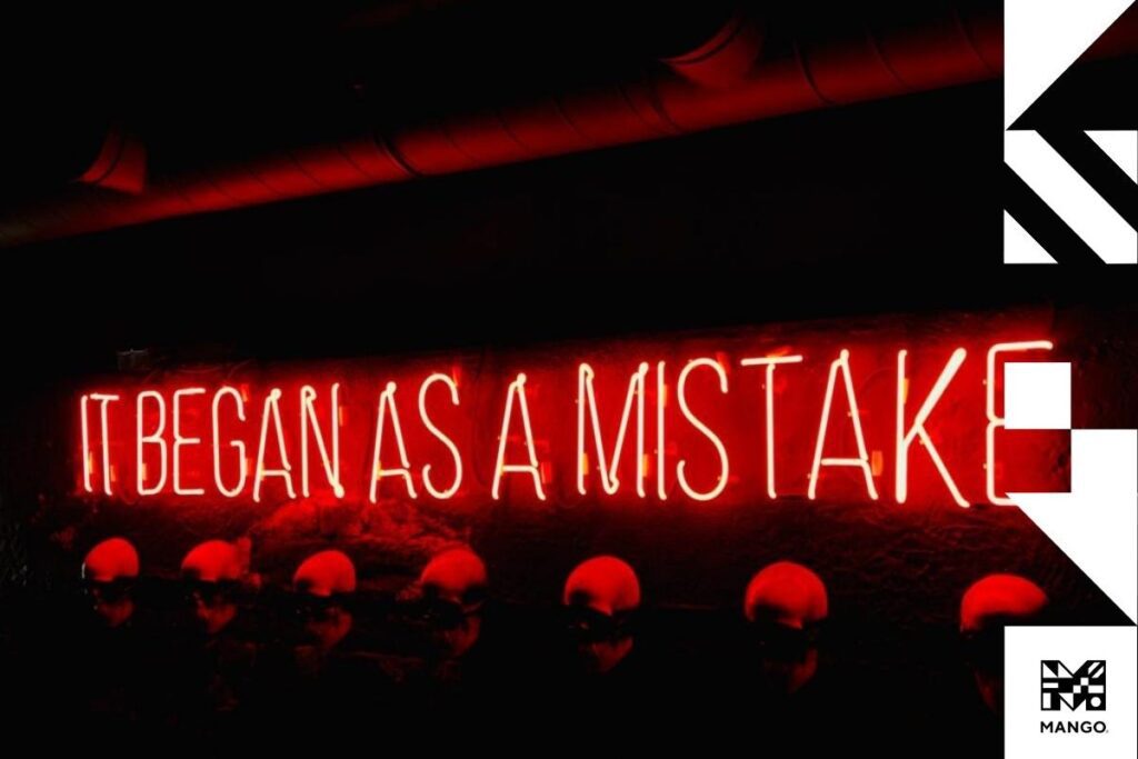 A red neon sign that says: "It began as a mistake"